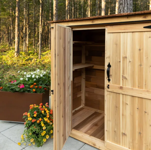 Cedar shed with open doors, flowers.