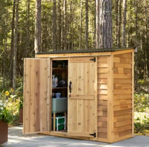 Wooden shed in forested setting.