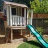 Colorful playhouse with green slide.