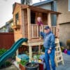 Child playing in wooden playhouse.