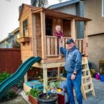 Child playing in wooden playhouse.
