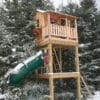 Wooden playhouse with green slide.