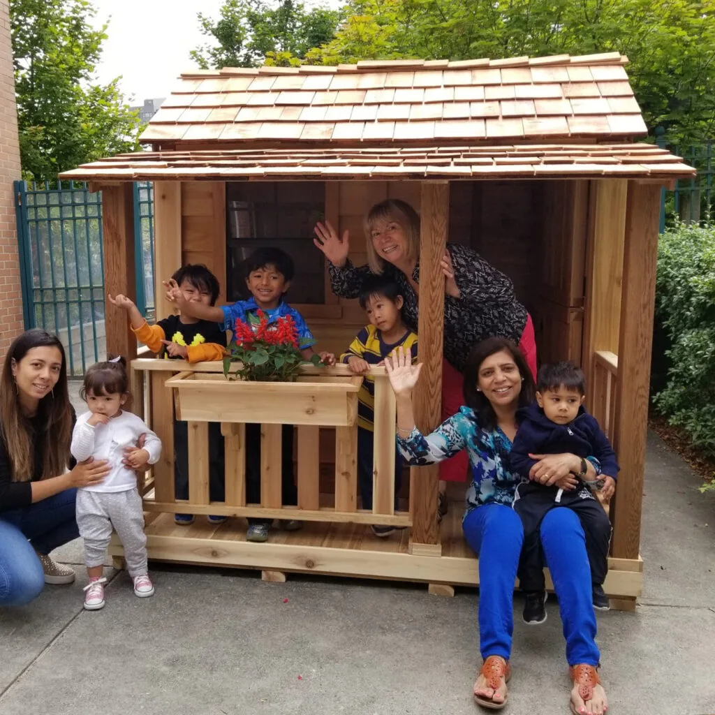 Children playing in a wooden playhouse.