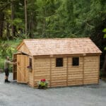 Wooden shed in a forested area.