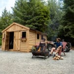 Friends enjoying fire outside cabin.