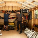 Men organizing tools in shed.