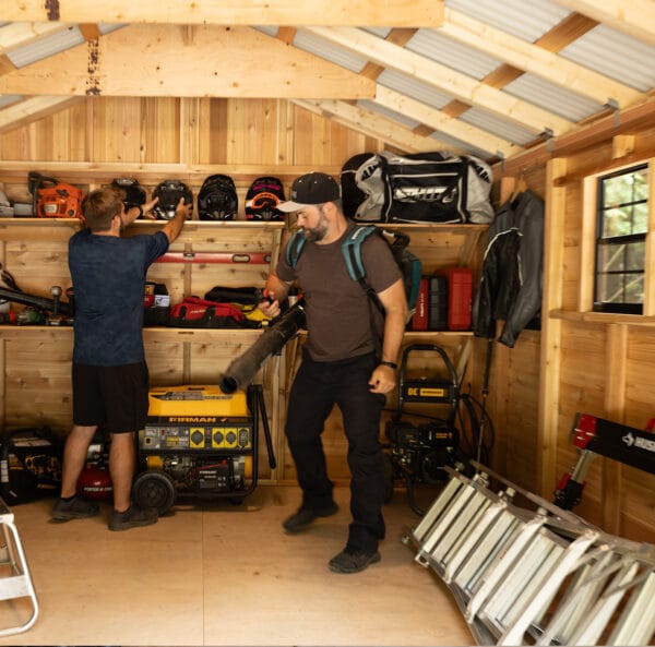 Men organizing tools in shed.