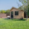 Wooden shed in green backyard setting.