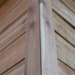 Close-up of wooden shed corner detail.