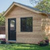 Wooden shed with black door and window.