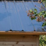 Metal roof with greenery nearby.