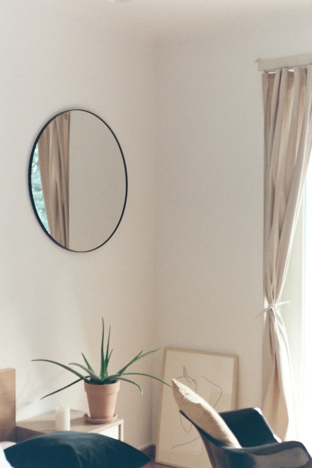 Photo by Laurence Ziegler round mirror with brown wooden frame