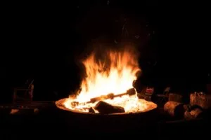A campfire burns brightly at night