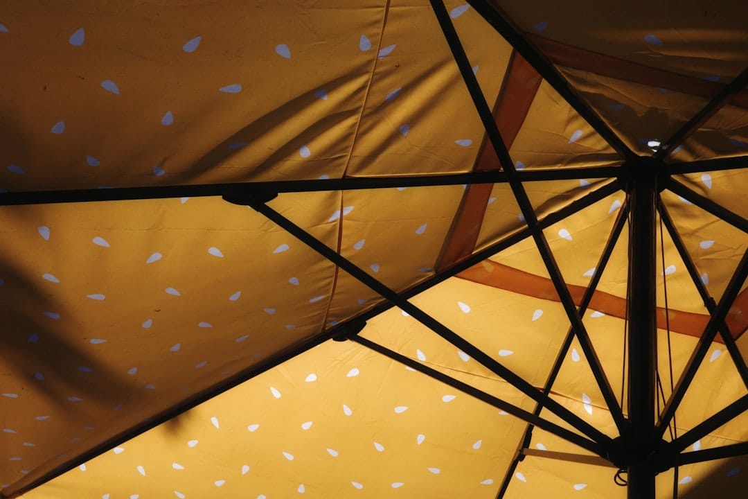Close-up view of a yellow umbrella with white polka dots.